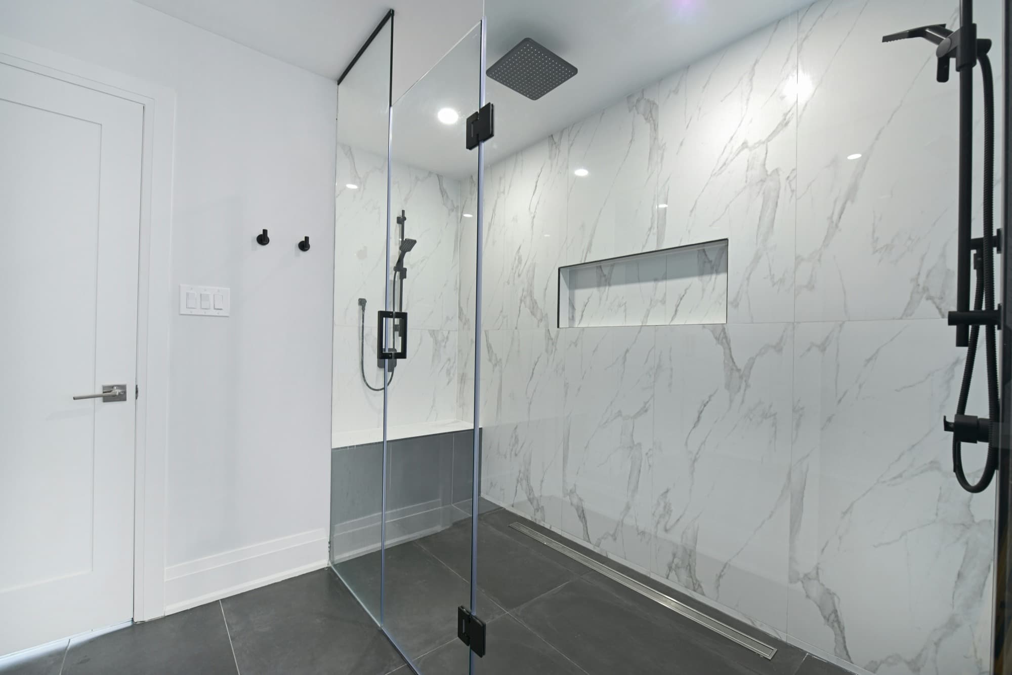 Modern bathroom with marble walk-in shower and black fixtures