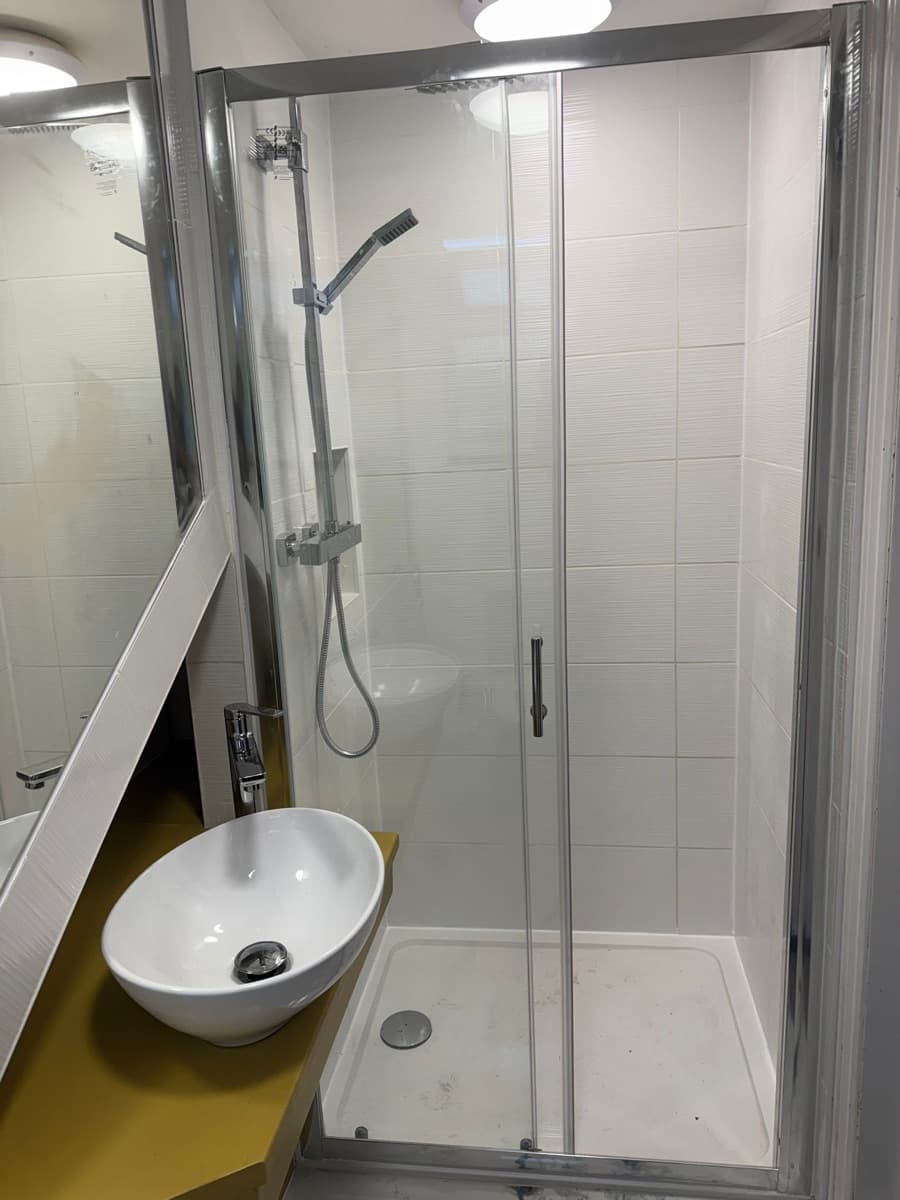 Glass shower enclosure in compact bathroom renovation