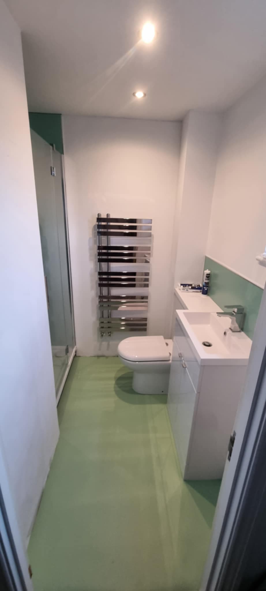 Green shower room with chrome towel rail