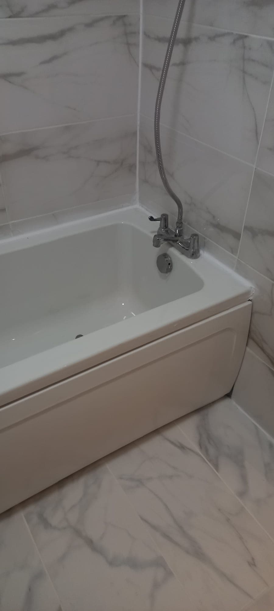 Marble bathtub with chrome mixer tap installation