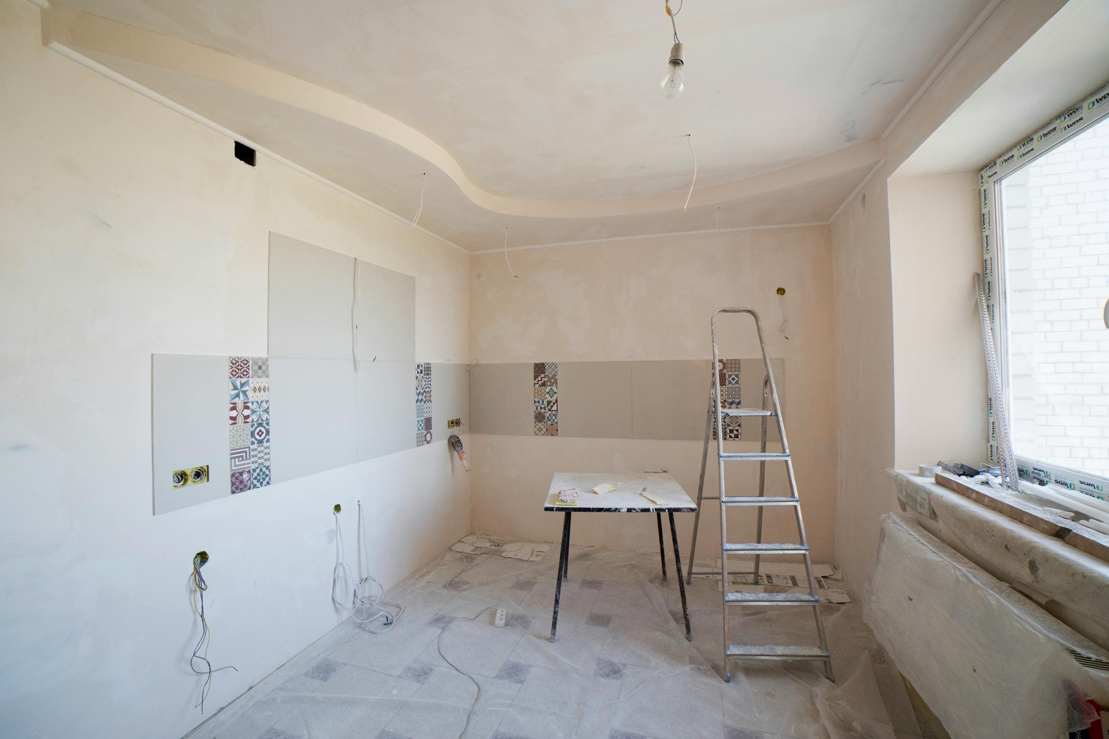 Modern room renovation with clean white walls and ladder