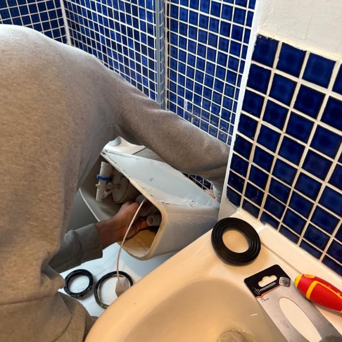 Plumber working on bathroom pipework in South London